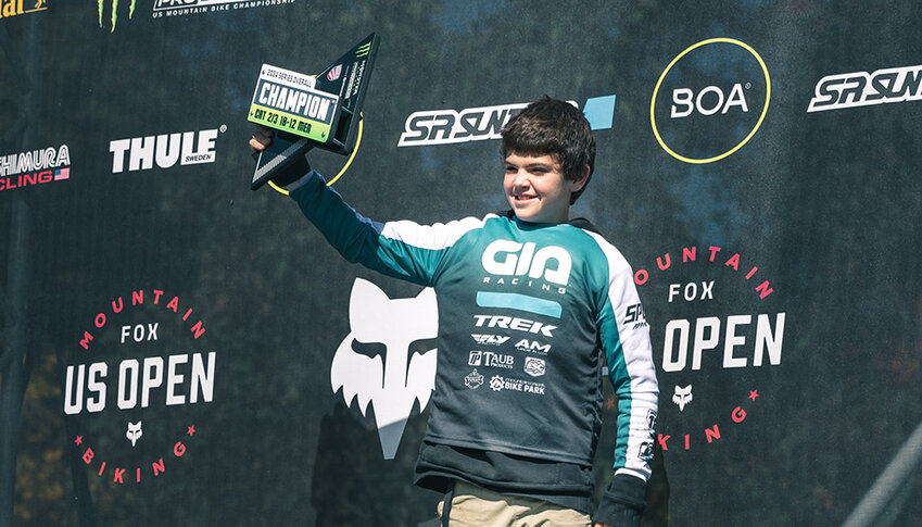 Ronin Rivas is shown holding the trophy at his last mountain biking event, the Fox US Open by Monster Energy Pro Downhill series.