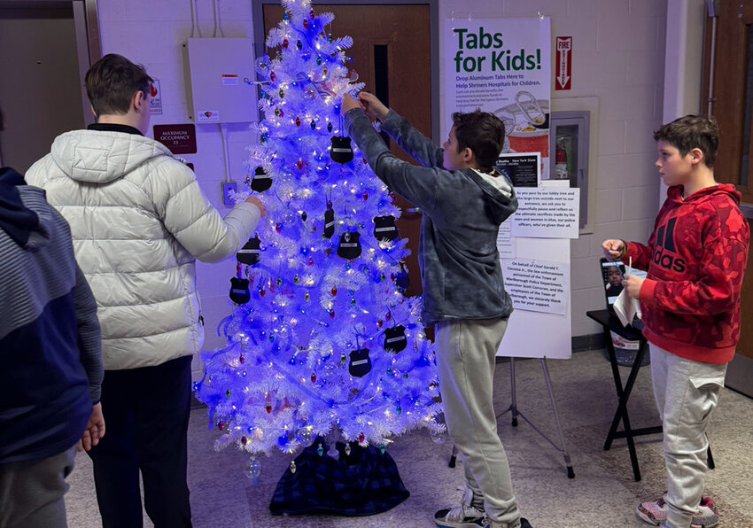 At Marlborough&rsquo;s annual Blue Light Tree Ceremony, Nunzio and Matteo Pascale, at right, hang special ornaments honoring the 13 police officers in New York who died in the line of duty this year. This was the 12th year in a row that the town has sponsored this ceremony.