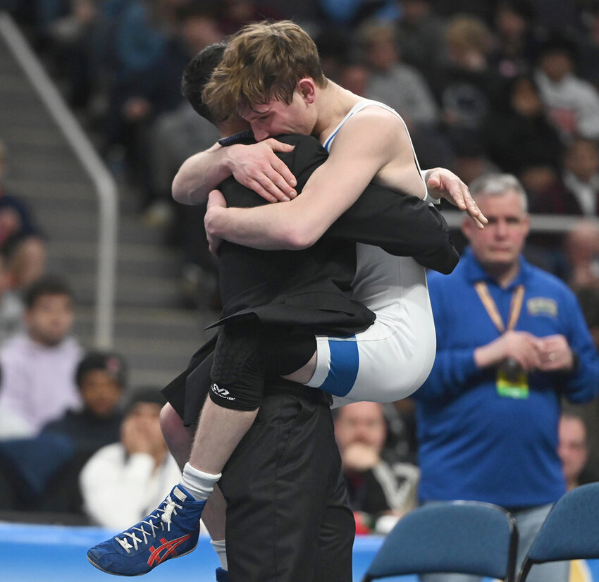 Valley Central’s Luke Satriano is congratulated after winning his third consecutive state wresting title.
