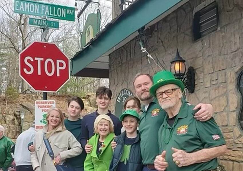 Eamon Fallon, proprietor of the South Gate Tavern, is shown surrounded by his family just after a new street sign designating the corner by his bar as Eamon Fallon Way.