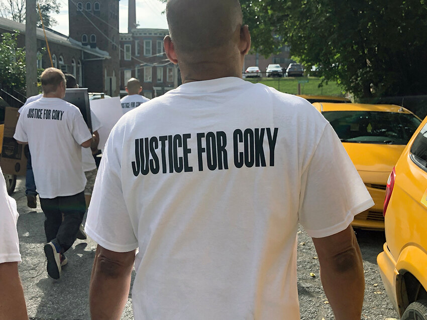 Justice for Coky is written on shirts as family, friends and fellow cabbies march for justice for Jorge Arbayza De La Cruz, murdered in 2021.