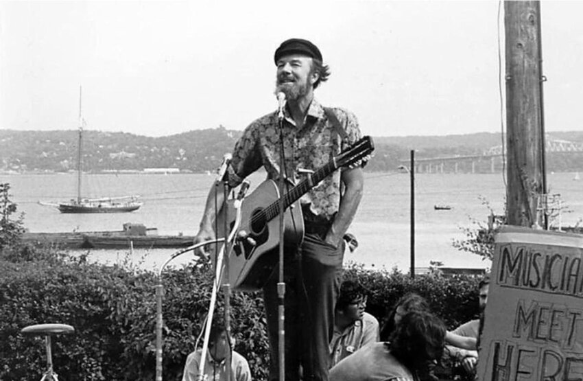 An iconic image of Pete Seeger, performing along the banks of the Hudson River.