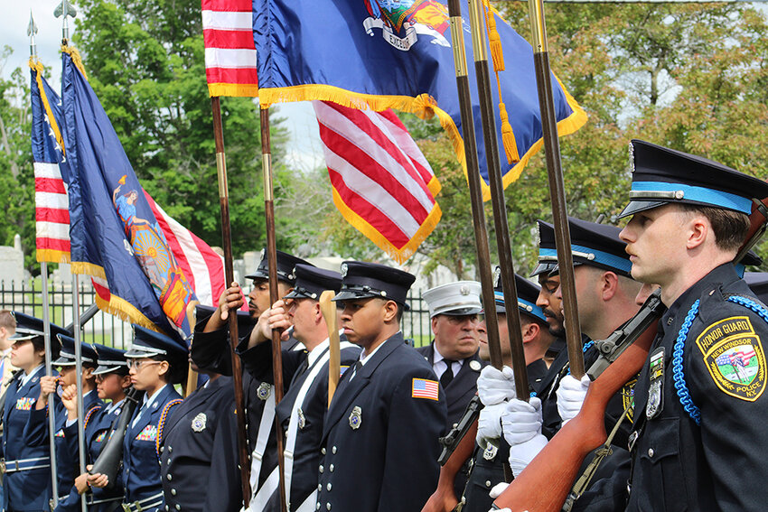 Various color guards stand at attention as the ceremony proceeds.