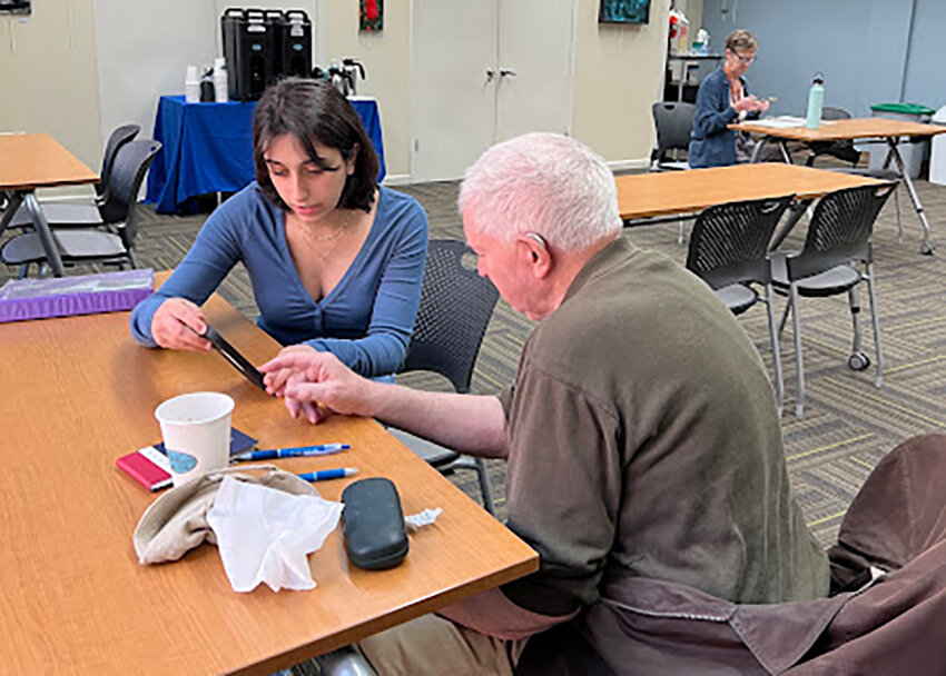 A teenage volunteers are shown working with a local senior citizens during the Cornwall Public Library&rsquo;s Teen Tech Tutors program.