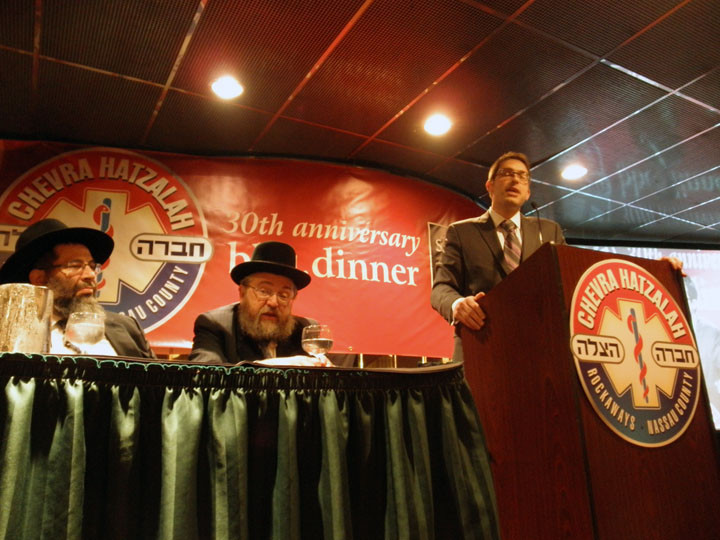 Hatzalah supporter Charlie Harary speaks alongside Rabbi Yaakov Bender and S. L. Wolkowitz.