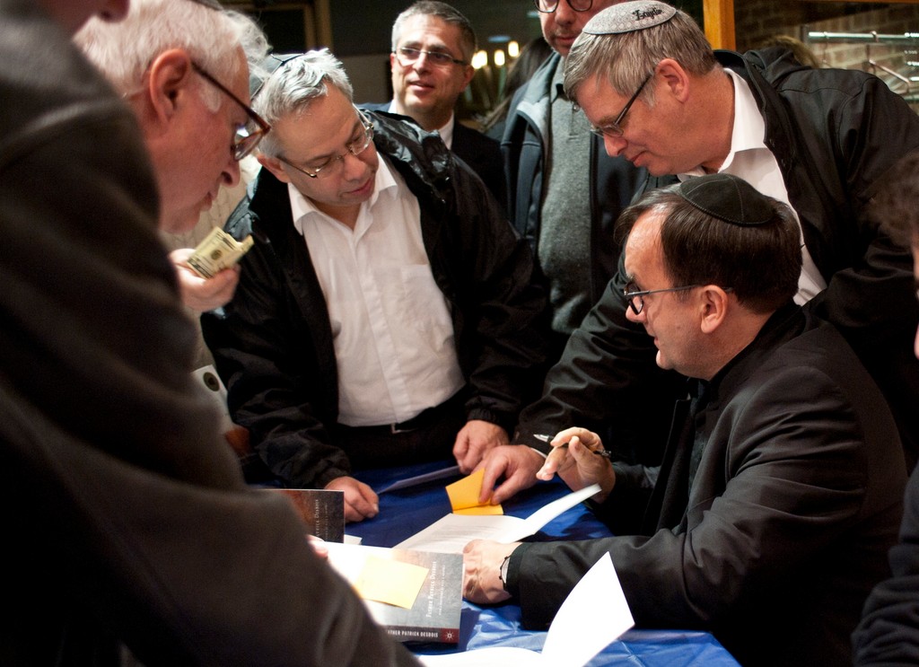 Photo by Isabel Slepoy  Although some expressed concern about a priest speaking at an Orthodox shul, Father Patrick Desbois&rsquo; lecture on his work in finding the graves of holocaust victims attracted a capacity crowd. Following his presentation, he lingered to answer questions and sign his book Holocaust by Bullets.