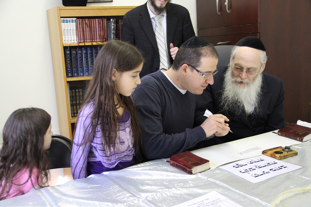 Dan Vaknine, accompanied by his children, writes in the Torah with Sofer Moshe Klein. The Torah writing marks the inauguration of the Chabad of Hewlett which is in honor of the   Assis and Greenfeld families. Chabad of Hewlett is located at 1160 Broadway in Hewlett. www.jewishhewlett.com
