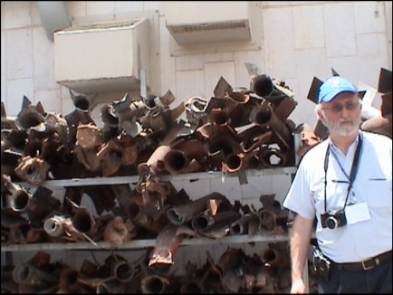 Dr. Michael Frogel by stacks of  Kassam rockets fired into Sderot.
