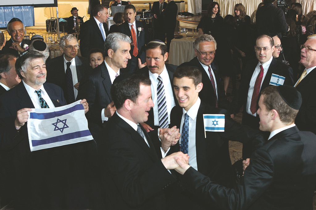 Marcus Lehmann, dances with his son Yehoshua. From left Dr. Paul Brody, holding Israeli flag, Dr. Elliott Greenfield; Steve Malzberg, Dr. Joe Frager, Lt. Col. Ralph Peters, keynote speaker.