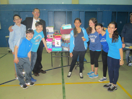 Rabbi Grossman with 6th and 7th graders showing their boxes