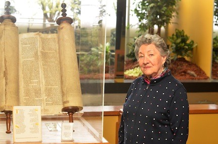 Ruth Mermelstein with a Holocaust Torah that her husband, Sidney, helped transfer from England to the East Meadow Jewish Center.
