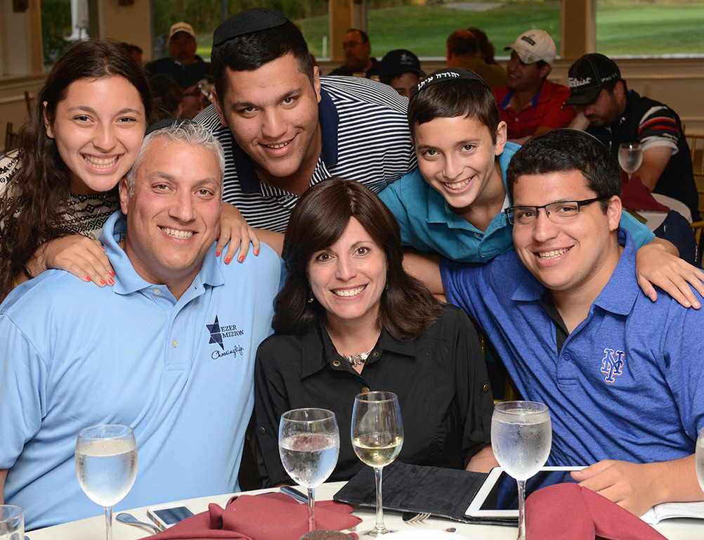 Job well done: Simeon and Beth Chiger are surrounded by their children, at the successful Ezer Mizion event at the Lawrence Yacht and Country Club.