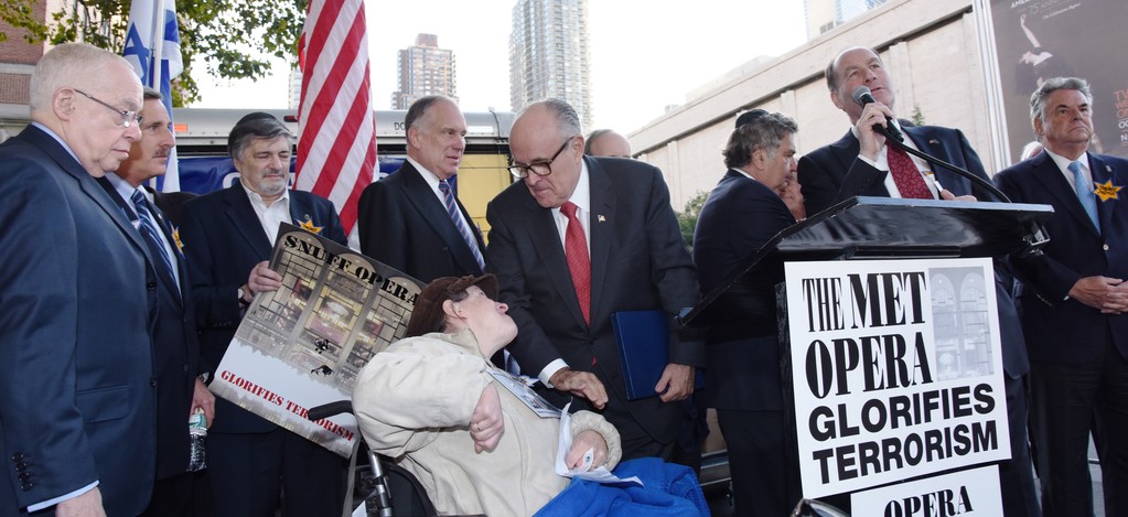 Left to right: Former Attorney General Michael Mukasey; Queens Assemblyman David Weprin; Stop the Terror Opera Coalition member Dr. Paul Brody, holding a protest poster; World Jewish Congress President Ronald Lauder; Mayor Giuliani conversing with Sharon Shapiro-Lacks, executive director, Yad HaChazakah