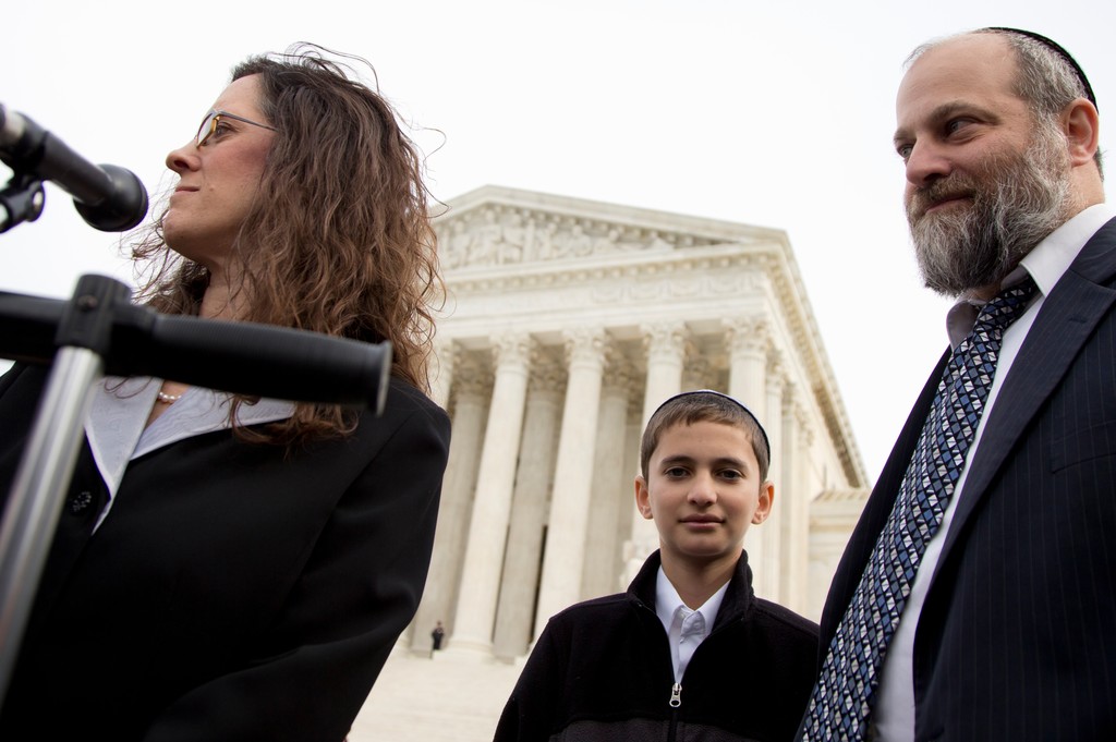 Menachem Zivotofsky stands with his father Ari Zivotofsky and attorney Alyza Lewin, outside the Supreme Court in Washington on Monday, Nov. 3.