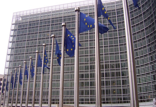 EU flags in front of the European Commission building in Brussels.