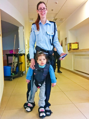 An Israeli police officer trains with a disabled child for the 2015 Jerusalem Marathon.