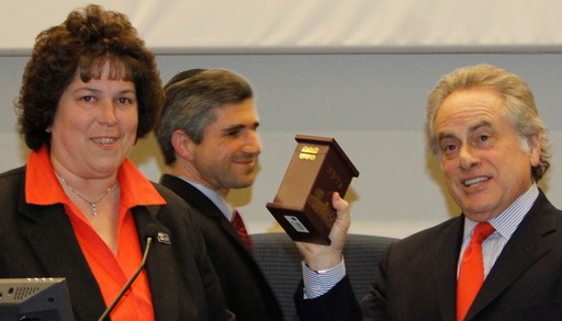 Attorney Benjamin Brafman accepts a tzedakah box after speaking after Touro Law Center in Central Islip. At left, Dean Patricia Salkin and  Samuel J. Levine, director of Touro