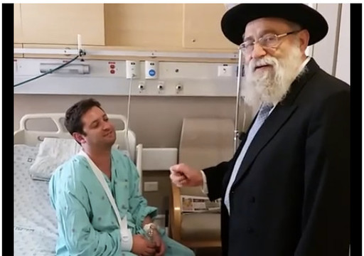 Rabbi Aryeh Stern with a wounded marcher in a Jerusalem hospital.