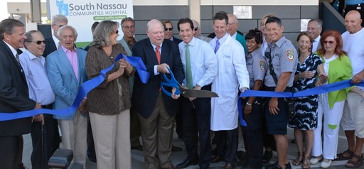 South Nassau Communities Hospital chairman, Joseph J. Fennessy, cuts the ribbon at the new Long Beach Emergency Department. He