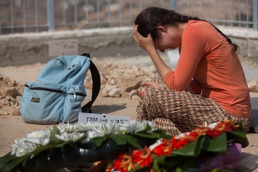 A woman mourns at the grave of Naama and Rabbi Eitam Henkin after their funeral at Har HaMenuchot Cemetery in Jerusalem on Friday, Oct. 2. The Israeli couple were shot dead while driving near the West Bank settlement of Itamar. Four of the couple
