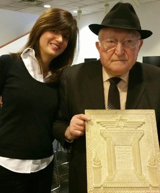 Harry Engelman of Woodmere, with daughter Debbie Shafran, holds memorial plaque he created to honor his family and the six million victims of the Shoah.