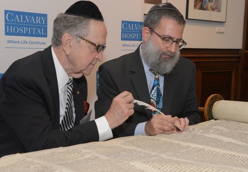Rabbi Moshe Druin of Sofer On Site (right) guides Dr. Michael J. Brescia as he writes the first letter in the Torah restoration.