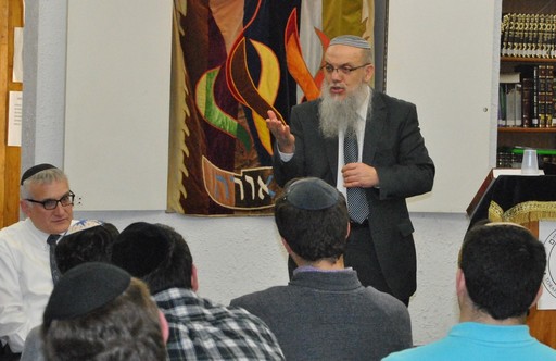 Rav Baruch Gigi speaks at Rambam last week. At left is Rambam&rsquo;s principal, Rabbi Yotav Eliach.