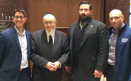 After his presentation, Chris Zaberto is flanked by (at left) event organizer Dovid Gerber, Kehillas Bais Yehudah Tzvi Rabbi Yaakov Feitman and (at right) event sponsor Yaakov Gade, president and CEO of Cross River Bank.