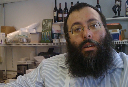 Rabbi Yossi Jacobson behind the counter of his Maccabees Kosher Deli in Des Moines, where he serves a serious pastrami sandwich.