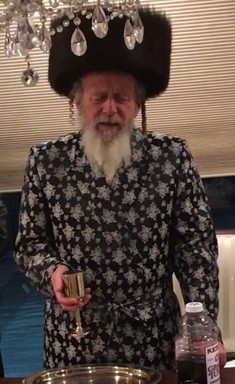 The Spinka Rebbe of Yerushalayim, Rabbi Avraham Yitzchok Kahana shlita, is pictured making havdalah in the Cedarhurst home of Avi and Sherry Ackerman, where he stayed recently while meeting with residents in the Five Towns.