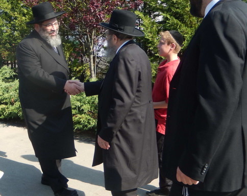 Rav Yaakov Bender greets Rav Kamenetsky.