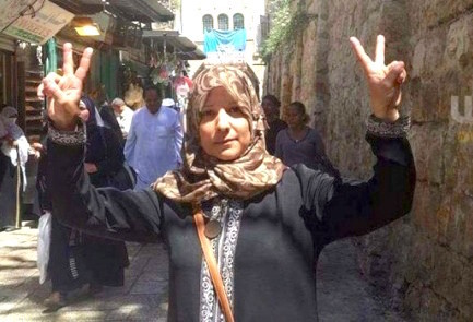 Suhair Halabi flashes &ldquo;V&rdquo; for &ldquo;Victory&rdquo; signs with both hands at the site where her son, Muhannad, carried out a deadly terrorist attack.