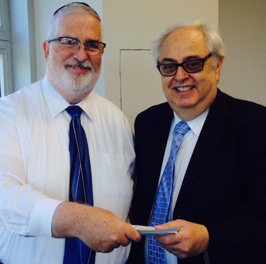 Dr. Shmuel Reisbaum of the Torah Academy for Girls presents a check to Irwin Gershon, senior development executive for New York&rsquo;s UJA-Federation.