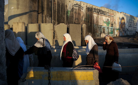 Palestinians cross the Qalandiya checkpoint, outside Ramallah, as they head to the Al-Aqsa mosque compound in Jerusalem, on June 10, 2016.