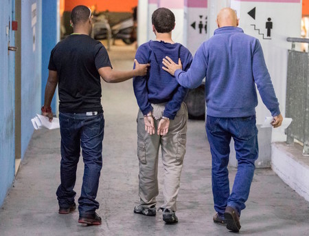 American-Israeli Jewish teenager, accused of making dozens of anti-Semitic bomb threats in the United States and elsewhere, is escorted by guards as he leaves the Israeli Justice court in Rishon Lezion on March 23, 2017.
