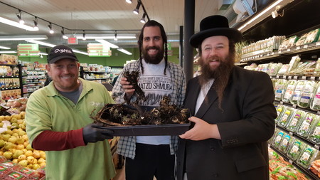 From right to left: Alexander Rapaport, co-founder of the Masbia Soup Kitchen, with Yisroel Bass, director of the Yiddish Farm, and an employee of Organic Circle, an all-kosher organic supermarket in Midwood, with organic horseradish for the seder.