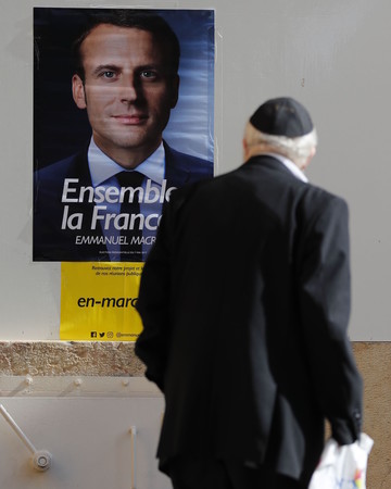 A Jewish man looks at an election poster of Emmanuel Macron at the French consulate in Jerusalem, on May 7, 2017.