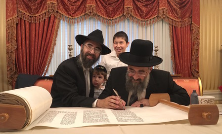 The new kehilla&rsquo;s rav, Rabbi Refael Ribacoff, his sons Avner Shmuel (left) and Moshe Ovadiya, and Rabbi Yitzchak Israeli completing the sefer Torah.