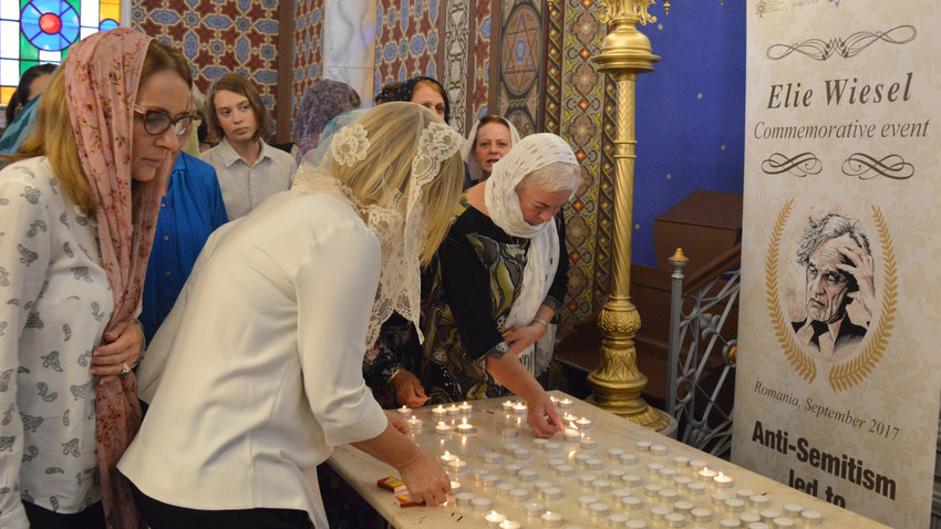 Women lighting candles in memory of Elie Wiesel at the synagogue in Ordea, in northern Romania, on Sept. 8.