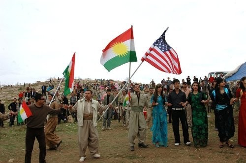 Local citizens wave Kurdish and American flags in Dahuk.