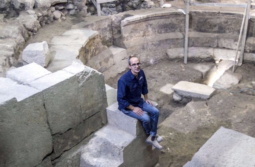 Joe Uziel of the Israel Antiquities Authority sitting on the steps of the Roman theater structure uncovered in the Western Wall tunnels.