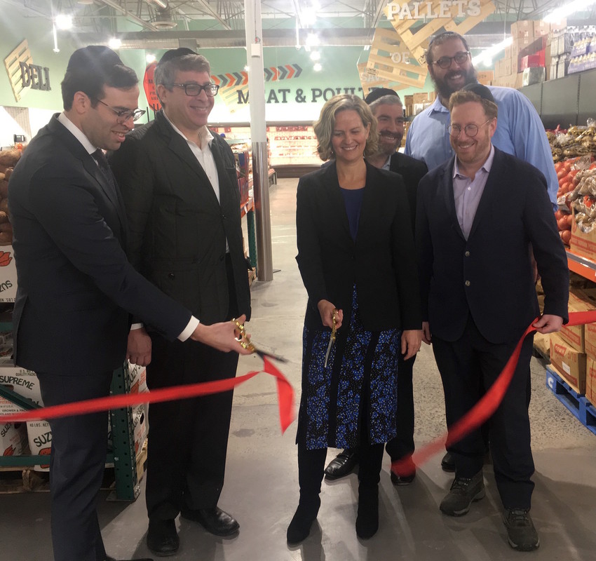 As the ribbon is cut at the opening of KolSave Market on Monday, Nassau County Executive Laura Curran is flanked (from left) by Achiezer Founder and President Rabbi Boruch Ber Bender, Gourmet Glatt's Yoeli Steinberg, Howie Klagsburn and Moshe Ratner, and (in back at right) KolSave store manager Mendy Herz.