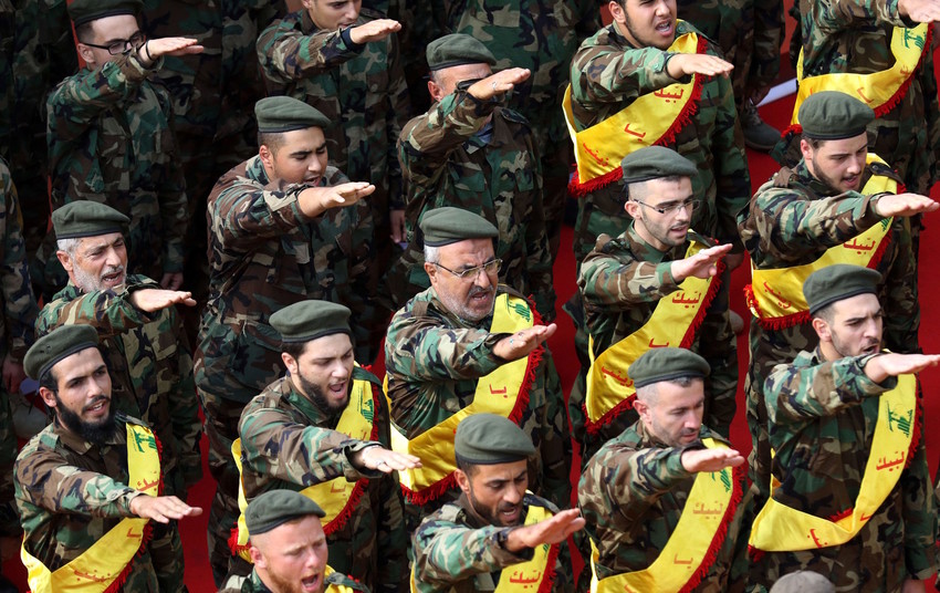 Members of Lebanon's Shiite Hezbollah movement salute behind the coffins of three comrades killed in combat in Syria during their funeral in the southern Lebanese city of Nabatieh on Nov 8, 2017.