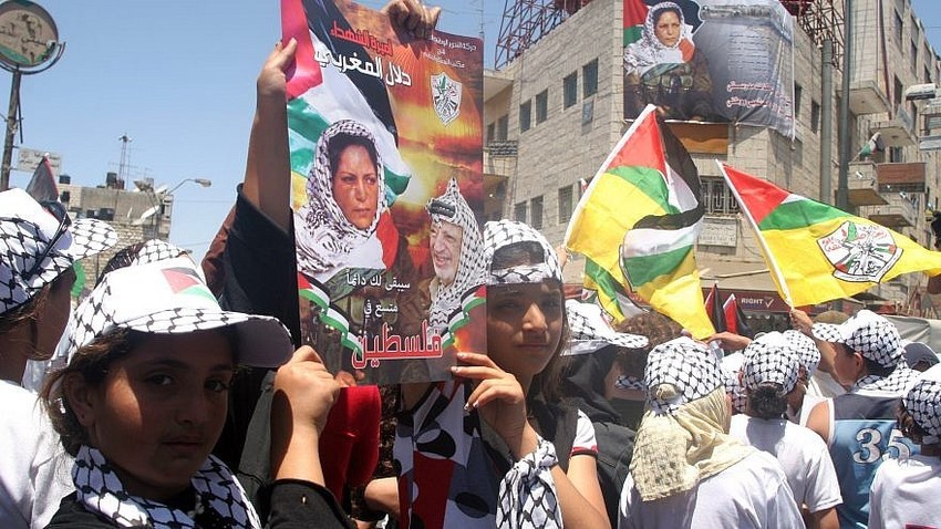 Palestinians hold posters showing terrorist Dalal Mughrabi.