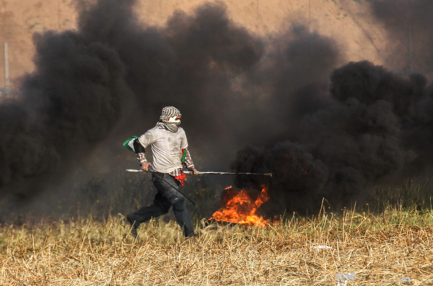 Palestinian protester burns tyres during clashes with Israeli forces near the border with Israel, east of Khan Yunis, in the southern Gaza Strip, on April 2.