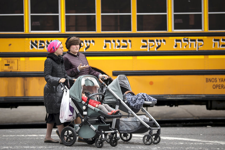 Women pushing strollers walk past the Yeshiva Kehilath Yakov School in the South Williamsburg on April 9.