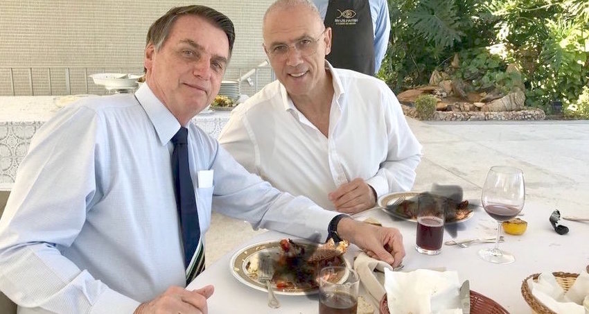 Israel's Ambassador to brazil Yossi Shelley dining with Brazilian president Jair Bolsonaro. The picture features a poorly doctored covering up (with black x marks) of the two men eating lobsters.