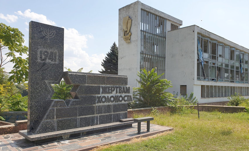 A Holocaust monument next to a deserted riverside building in Tiraspol, Transnistria.