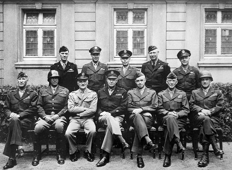 Senior American commanders of the European theater of World War II, circa 1945. Seated (from left): Gens. William H. Simpson, George S. Patton, Carl A. Spaatz, Dwight D. Eisenhower, Omar Bradley, Courtney H. Hodges and Leonard T. Gerow. Standing (from left): Gens. Ralph F. Stearley, Hoyt Vandenberg, Walter Bedell Smith, Otto P. Weyland and Richard E. Nugent.
