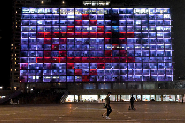 The Tel Aviv municipality on Rabin square is lit up the Magen David Adom logo on March 30.
